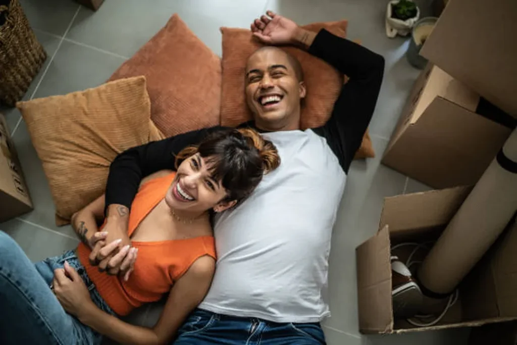 couple laughing on floor after moving in